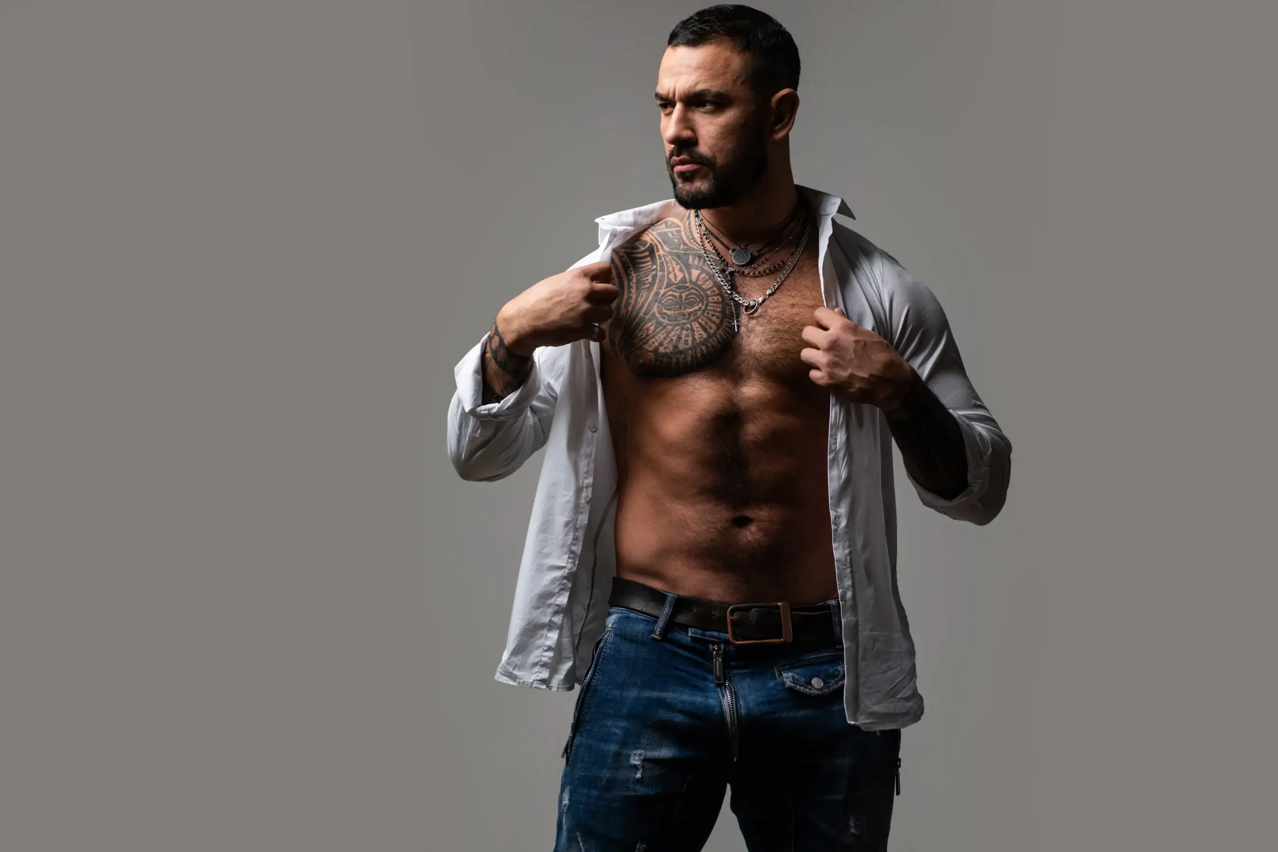Athletic man with tattoo putting on a shirt