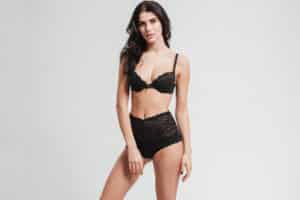Woman in black bra and underwear has rejuvenated appearance after breast lift surgery