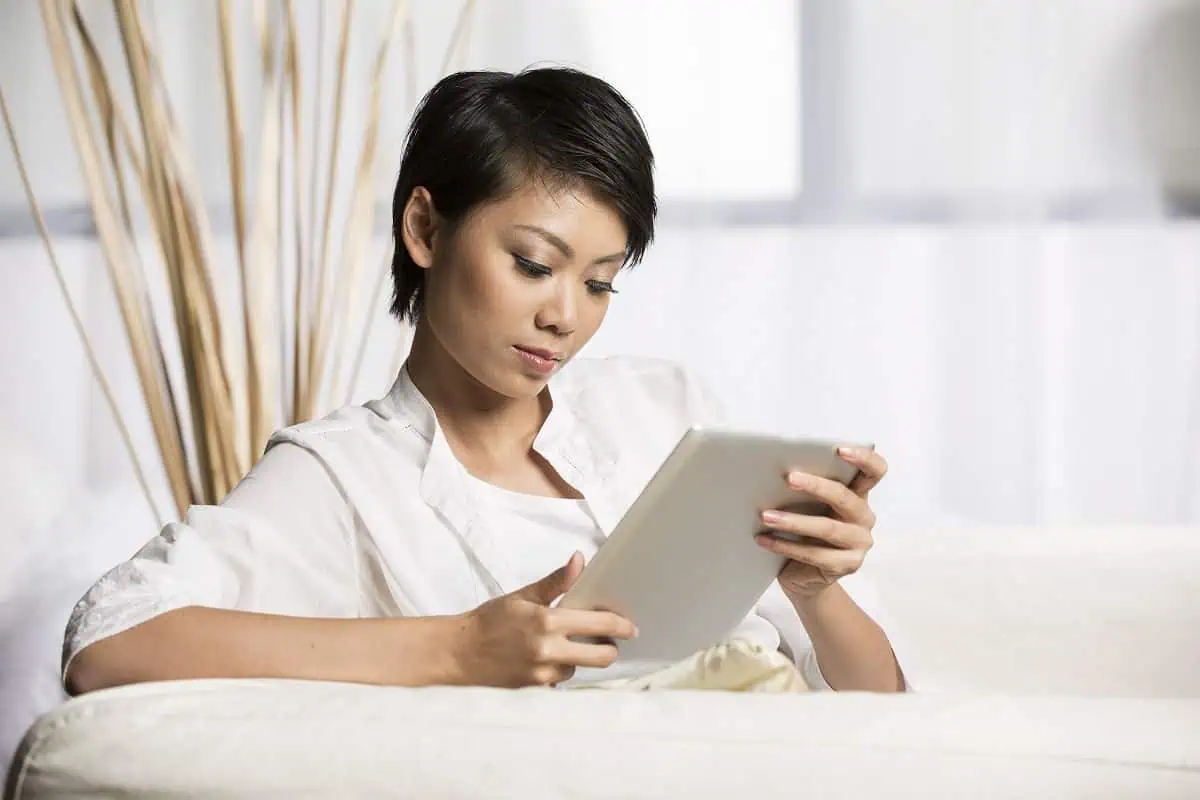 Woman reading explant reviews on a tablet computer