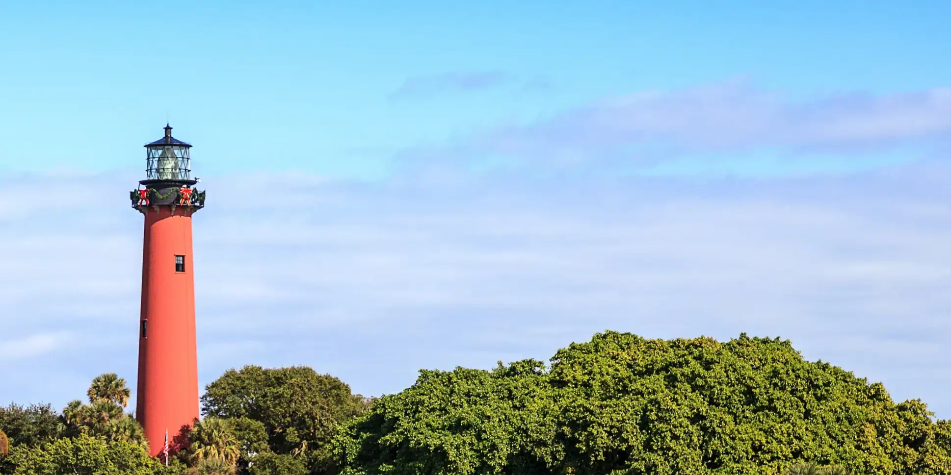 Red lighthouse in Jupiter, Florida, with boats floating by