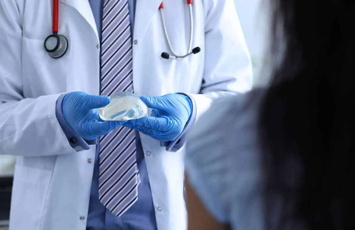 Doctor with gloves holds a gel breast implant